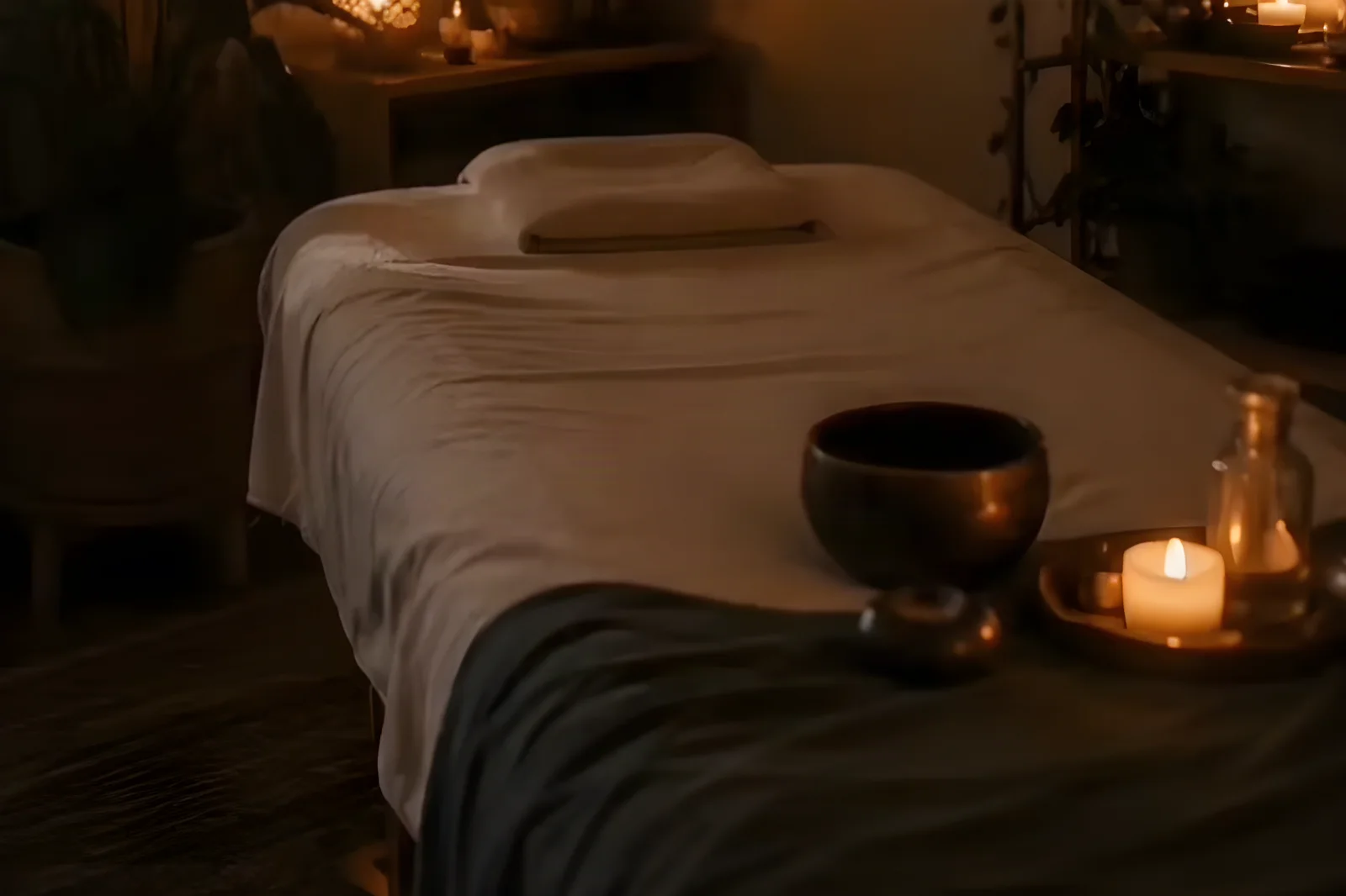 La camilla de masaje, con velas y un cuenco tibetano